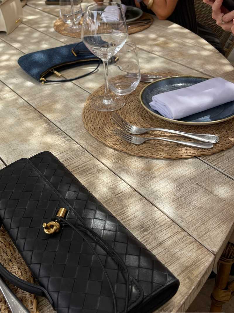 Women's chic woven clutch bag with a sleek knot closure, versatile for any event.