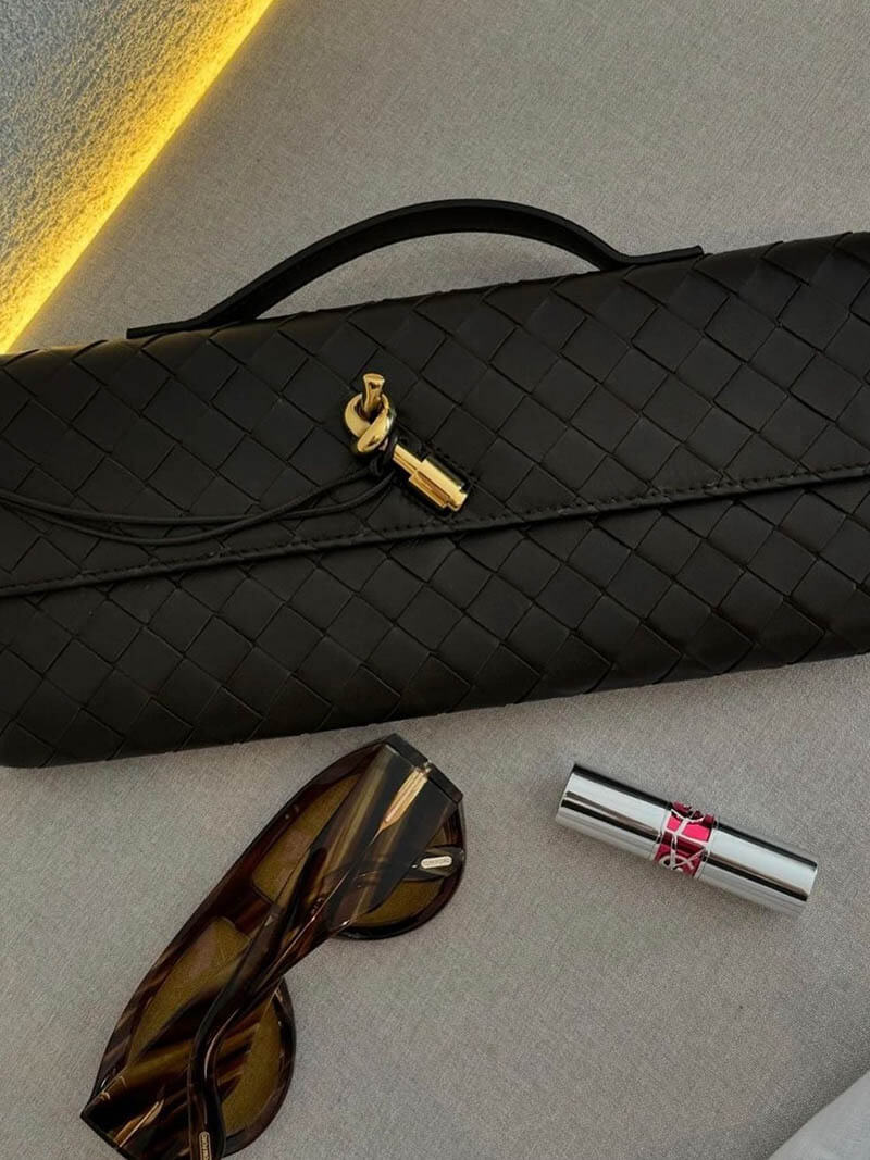 Women's chic accessory: a woven clutch with an elegant knot closure, perfect for evenings.