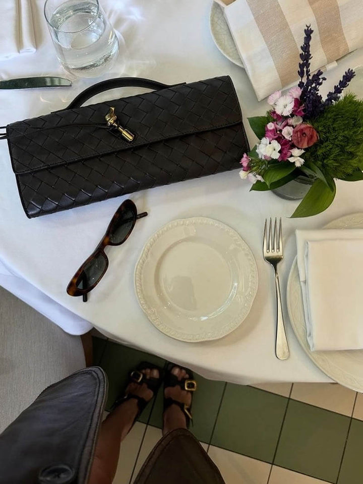 Compact and chic women's woven clutch, an evening handbag with a distinctive knot closure.