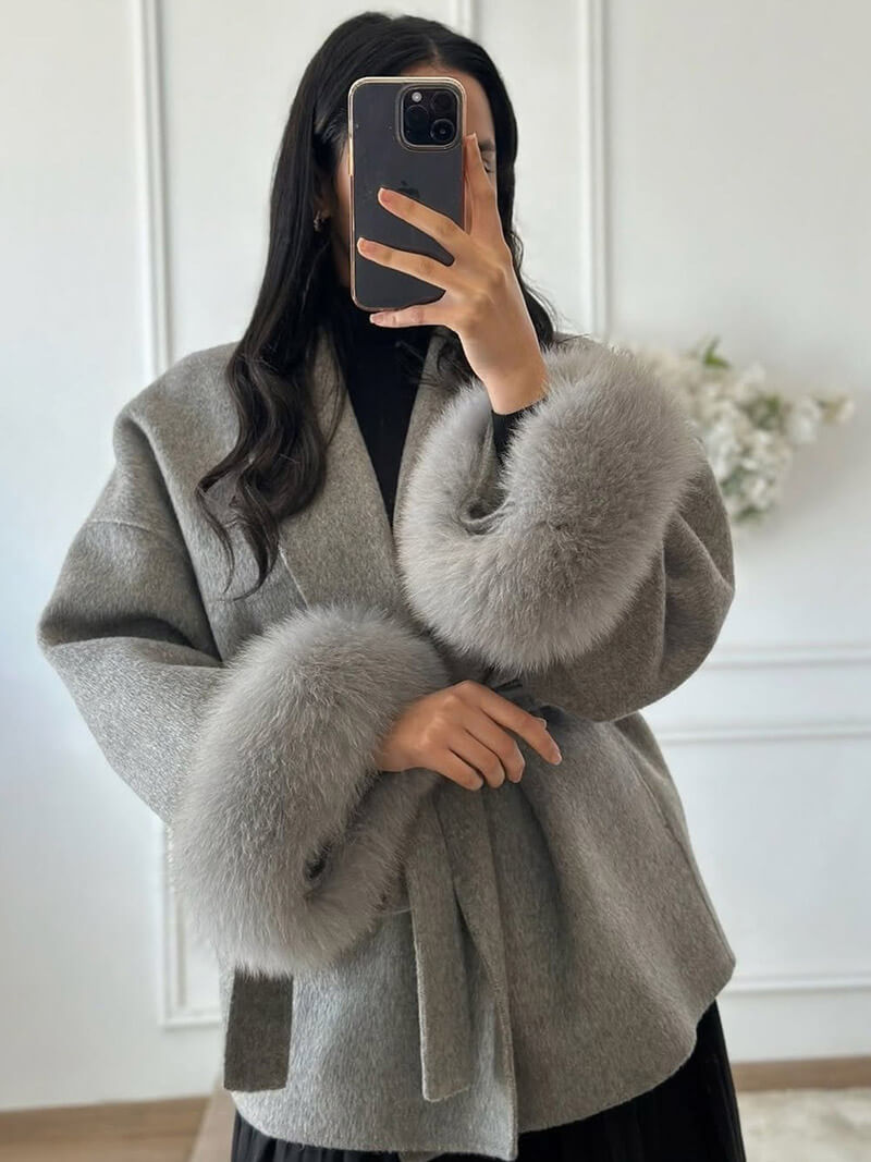 Chic women's long wrap coat featuring a tie waist and stylish faux fur cuffs.