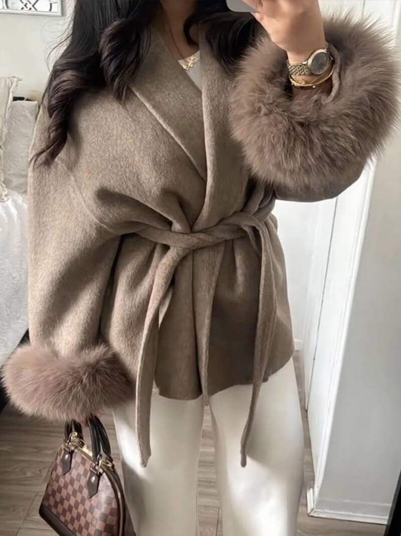 Chic women's winter outerwear: a belted wrap coat with plush faux fur cuffs for warmth & style.