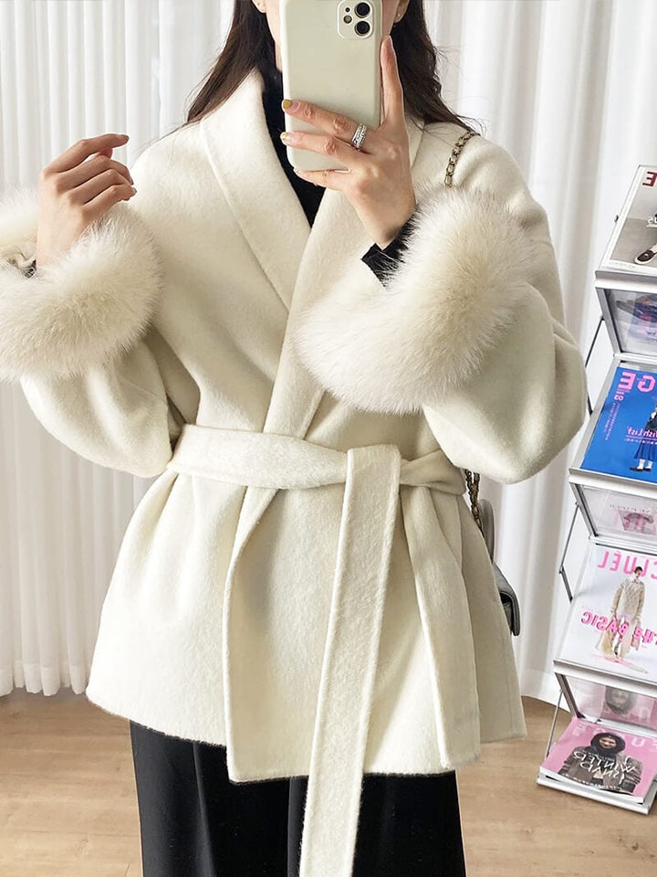 Luxury women's belted winter coat, a sophisticated outerwear piece with elegant faux fur cuffs.