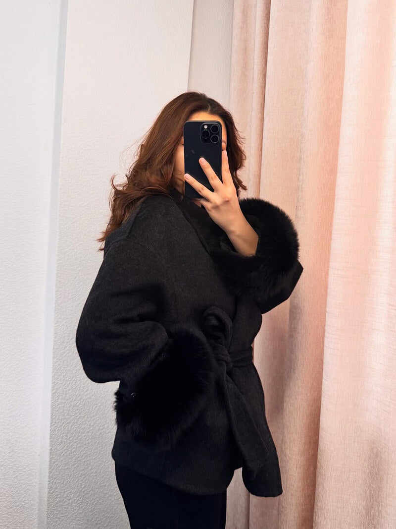 Stylish women's outerwear: belted wrap coat with elegant faux fur cuffs, ideal for chilly days.