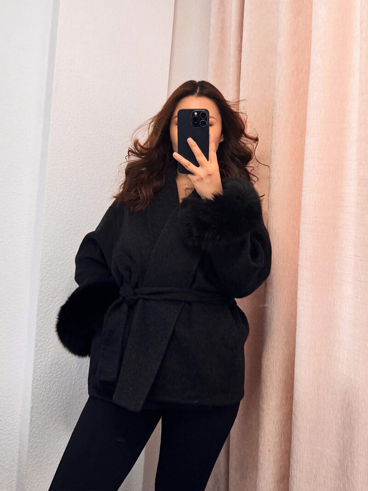 Elegant women's wrap coat, featuring a tie waist and stunning faux fur cuffs for winter chic.