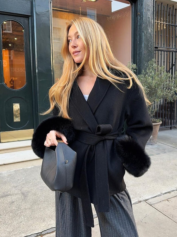 Elegant women's long belted coat, a sophisticated wrap style with plush faux fur cuffs.