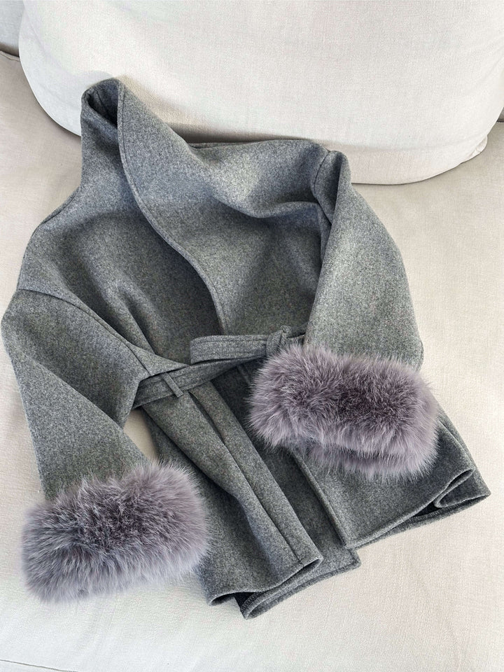 Women's elegant outerwear: a long belted wrap coat with luxurious faux fur details.