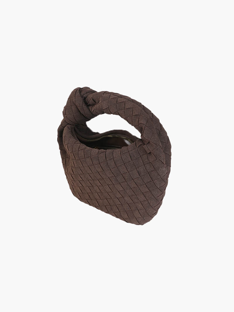 Stylish women's compact suede handbag with intricate braided detail.