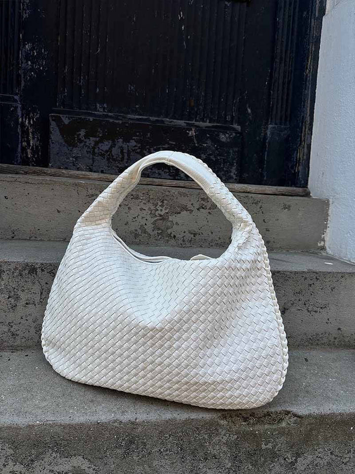 Elegant women's fashion accessory: a spacious woven shoulder bag in chic vegan leather.