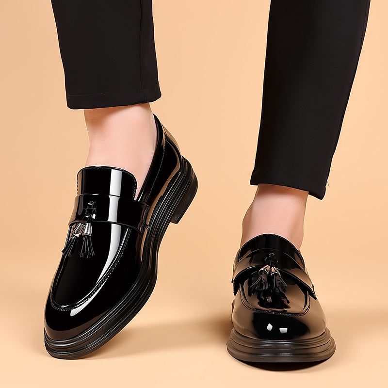 Men's polished black leather tassel loafers, a sleek slip-on dress shoe for business and formal occasions.