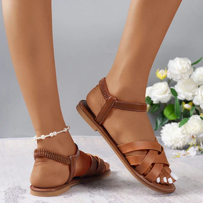 Comfortable women's brown flat cross strap sandals, ideal for vacation, beach, or casual summer style.