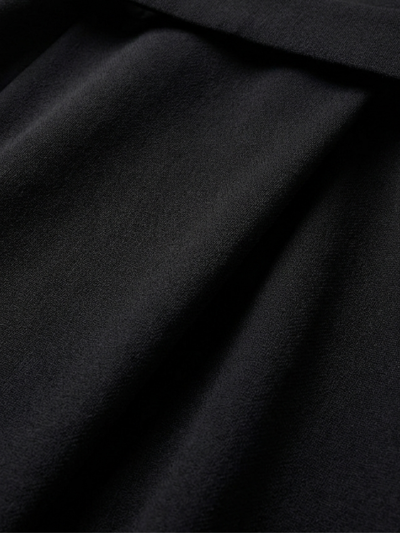 Sophisticated women's black midi dress, waist-defined, featuring unique cape sleeves and an asymmetric cut.