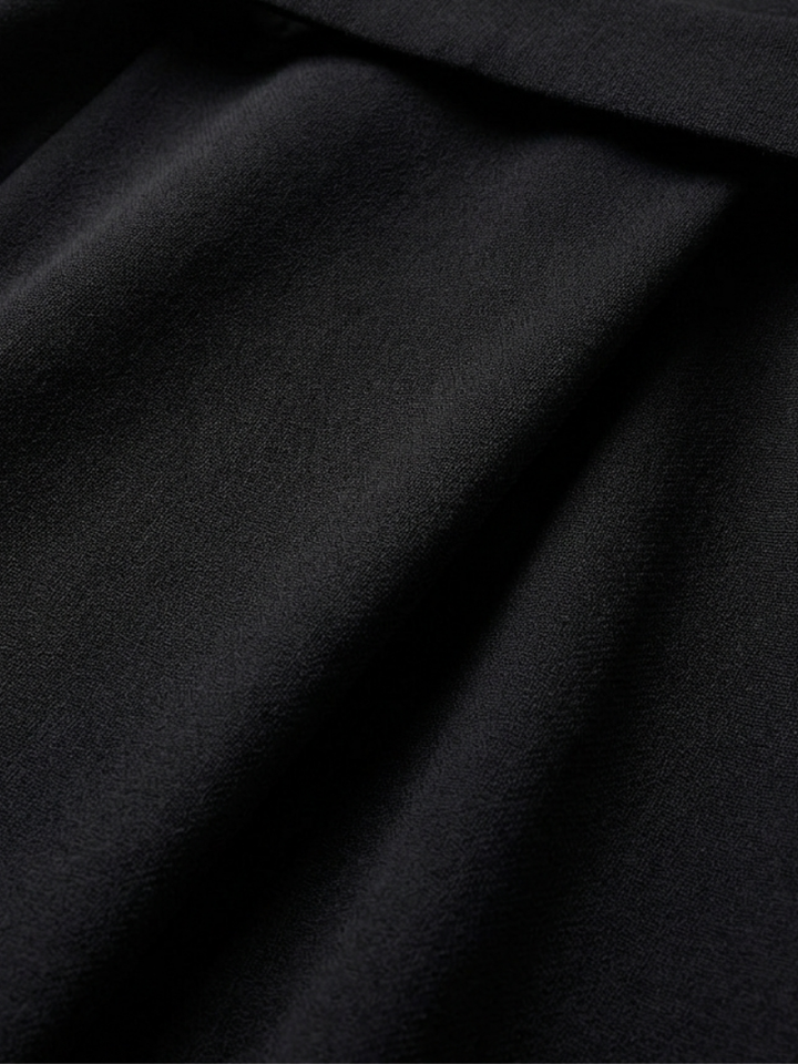 Sophisticated women's black midi dress, waist-defined, featuring unique cape sleeves and an asymmetric cut.