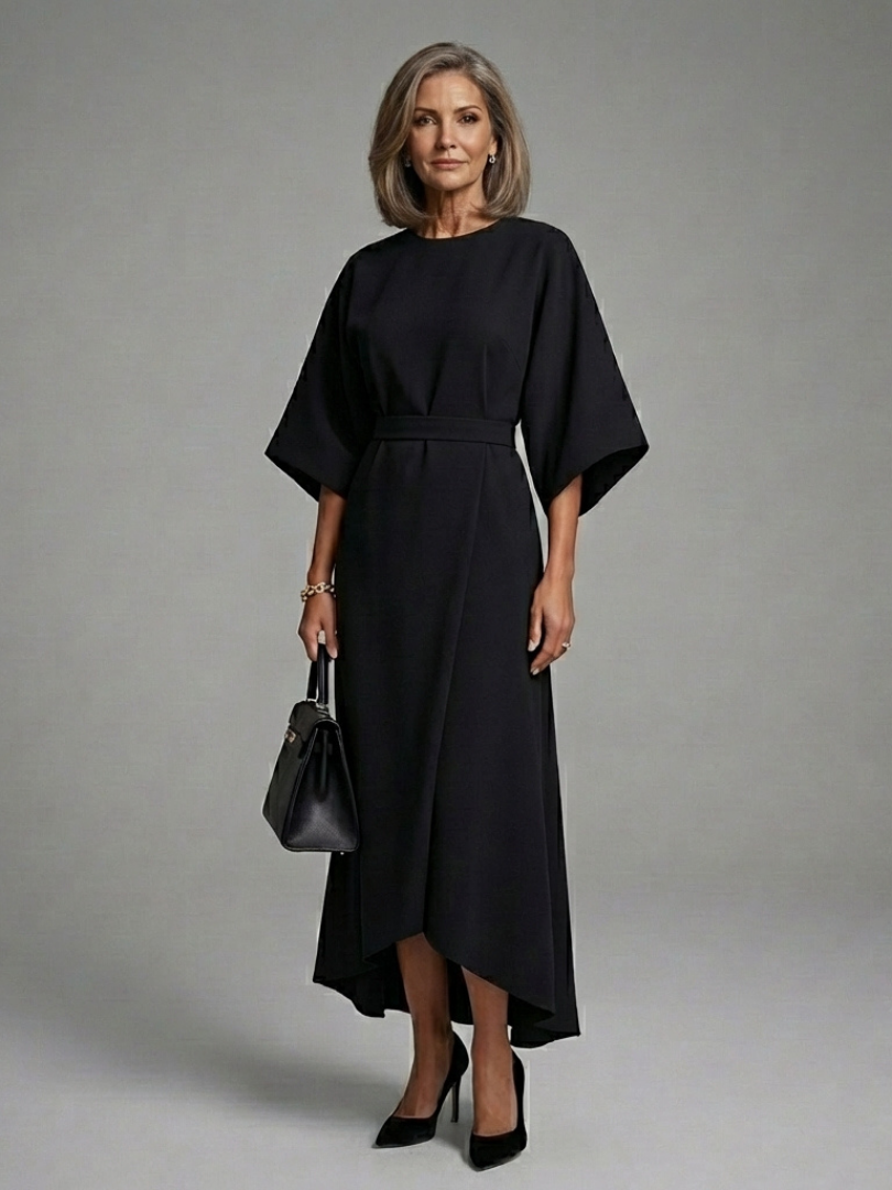 Elegant black women's midi dress featuring cape sleeves, asymmetric hem, and waist-defined silhouette. Perfect for evening.