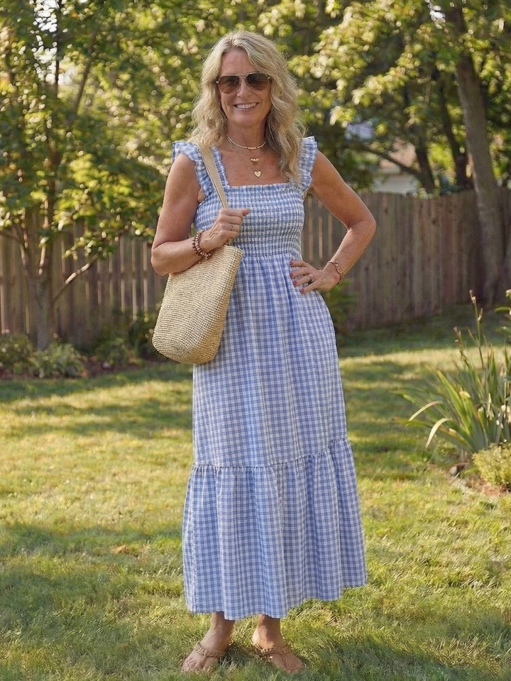Elegant & versatile women's smocked gingham maxi dress with flutter sleeves, suitable for casual summer occasions.