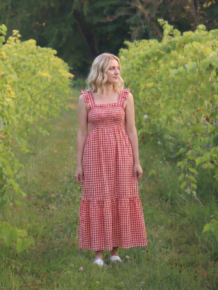 Feminine women's smocked gingham maxi sundress, featuring flutter sleeves, a charming look for warm weather.