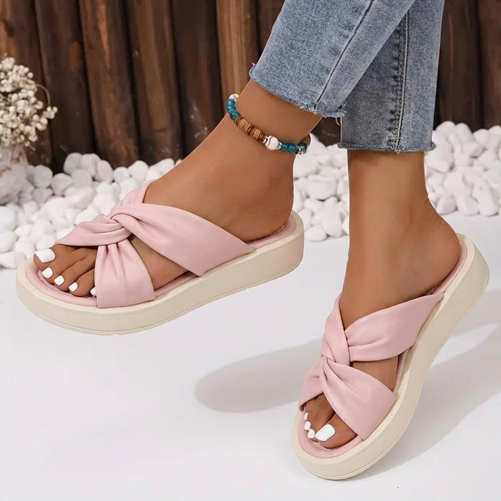 Elegant women's slip-on sandals featuring a unique twist crossover design, cushioned for comfortable everyday wear.