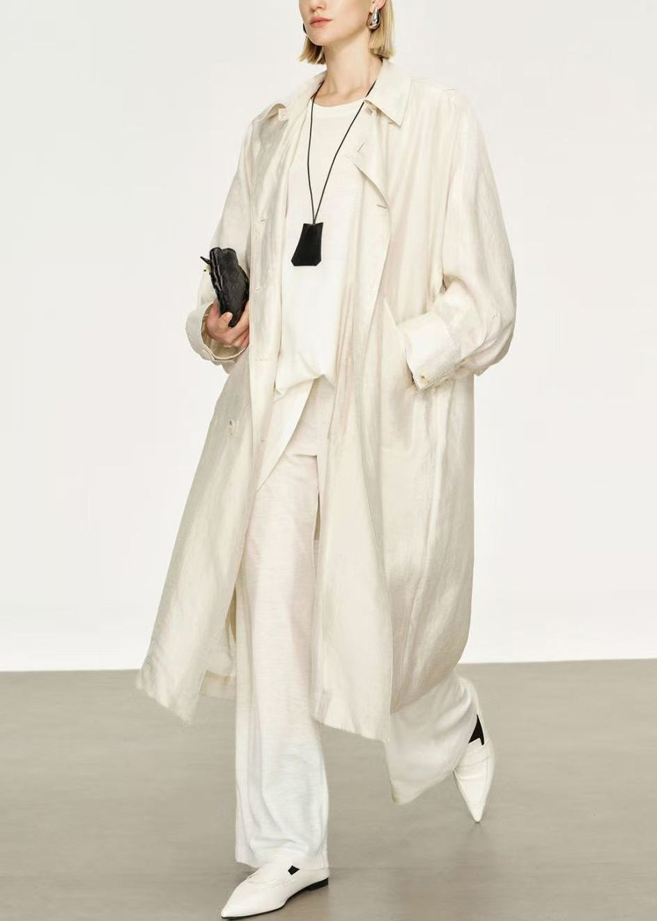 Stylish women's long trench coat with elegant Peter Pan collar and bat sleeves. Versatile autumn fashion.
