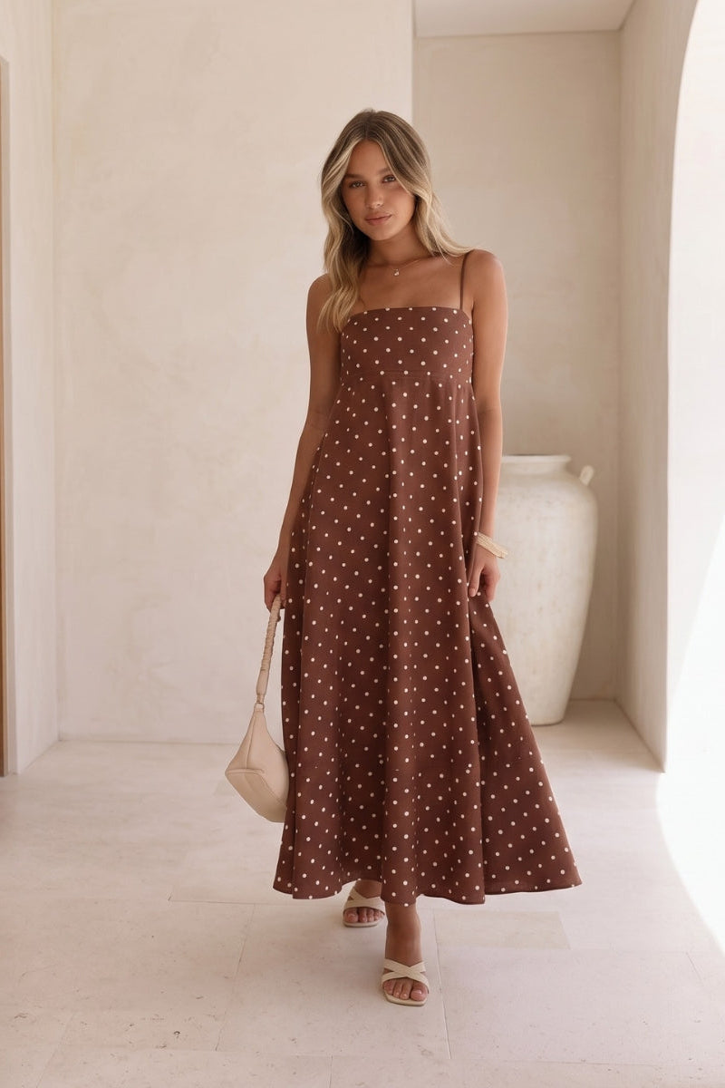 Women's flowy polka dot maxi dress, sleeveless, perfect for casual summer days or elegant vacation wear.