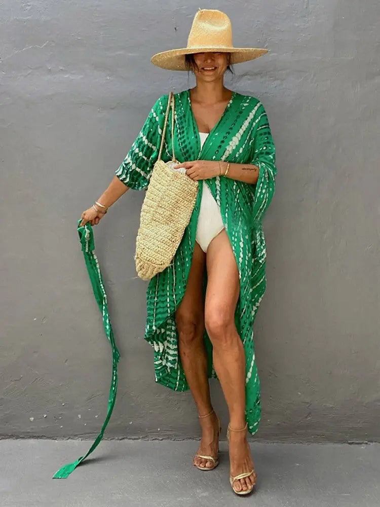 Woman wearing a tie-dye beach sarong cover-up at a sunny poolside.
