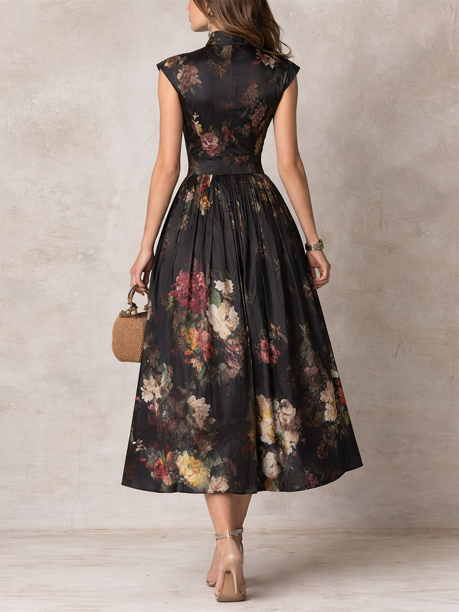Sophisticated black midi dress featuring a vibrant floral print, keyhole neckline, and flowy pleated A-line skirt.