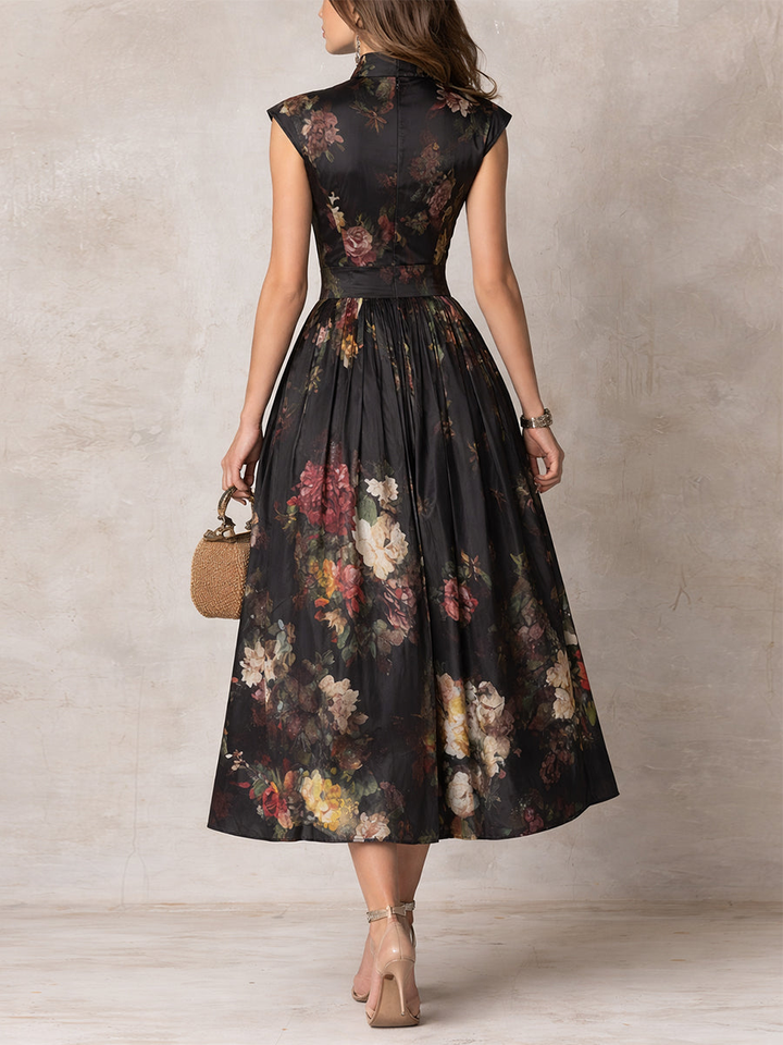 Sophisticated black midi dress featuring a vibrant floral print, keyhole neckline, and flowy pleated A-line skirt.