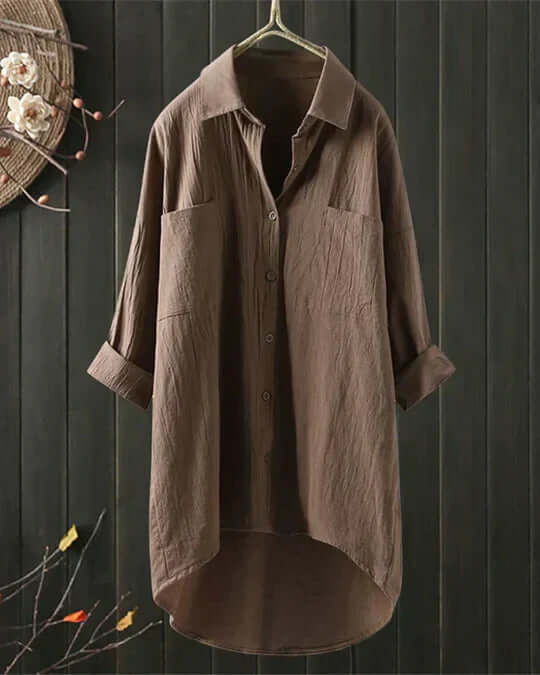 Elegant white button-down women's flowy blouse. Loose fit, long-sleeve summer top, comfortable for everyday fashion.