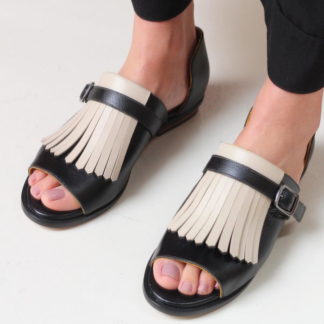 Comfortable women's slip-on sandals with black fringe detail. Perfect casual open-toe summer shoes for effortless style.