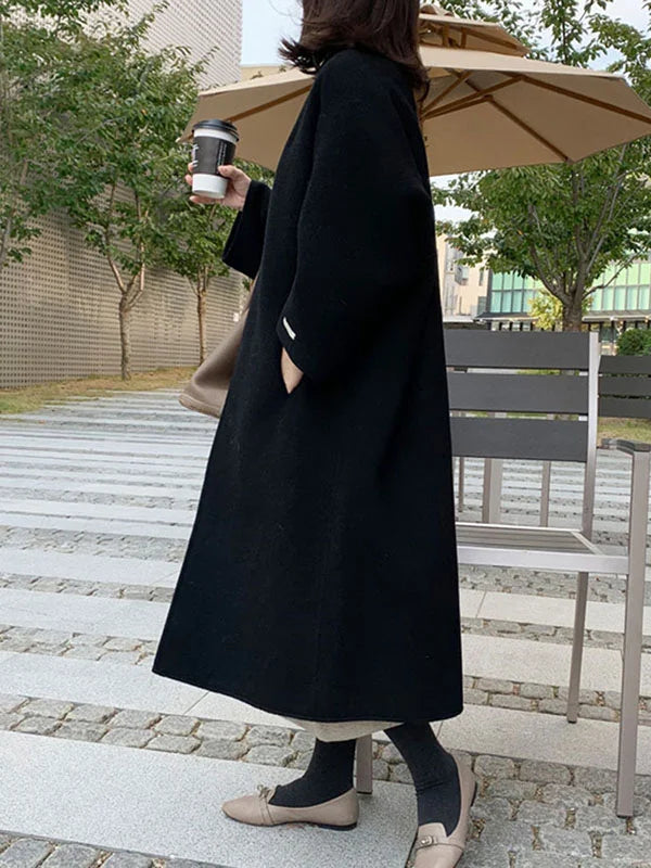 Stylish black women's long winter coat, offering warmth and a timeless elegant silhouette.
