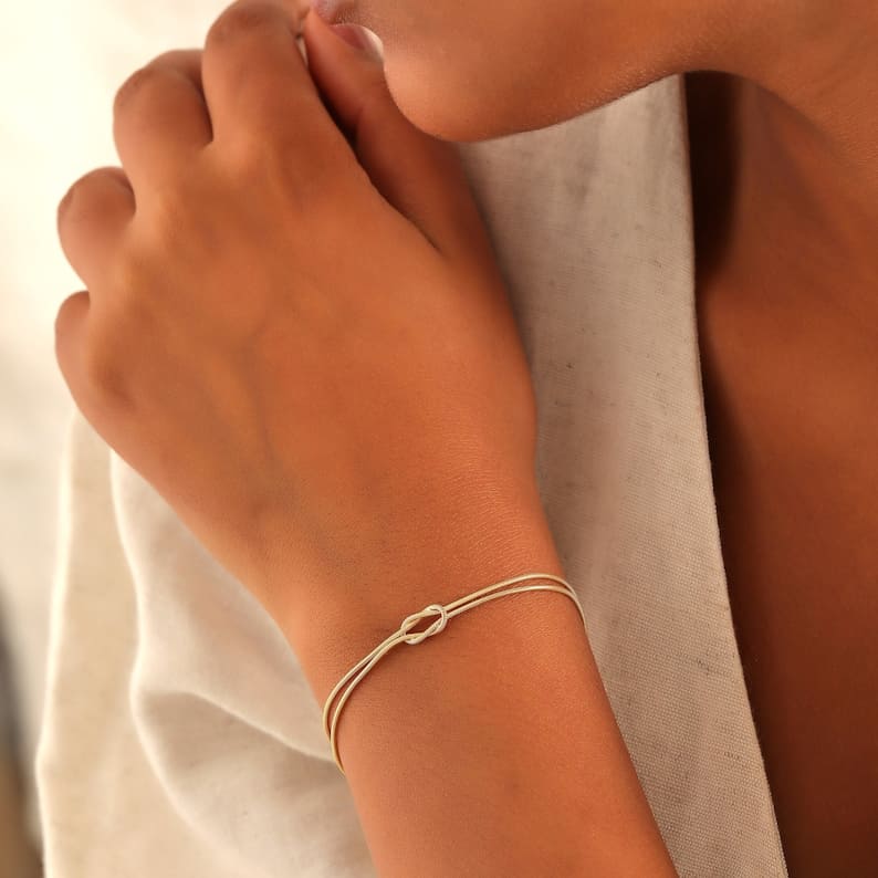 Stackable silver love knot bracelet, an elegant women's jewelry piece.