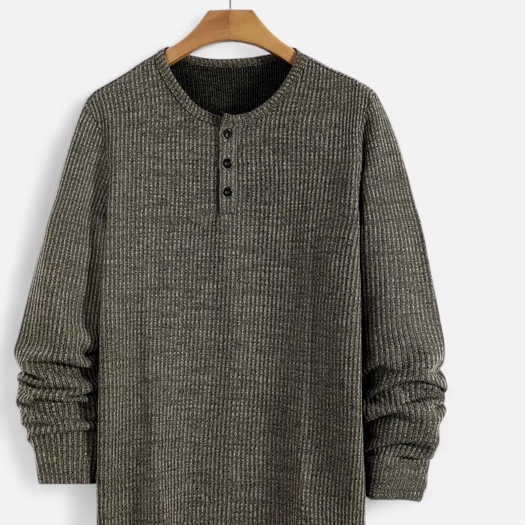 Man wearing a comfortable men's cable-knit henley sweater. Great for autumn fashion and casual outings.