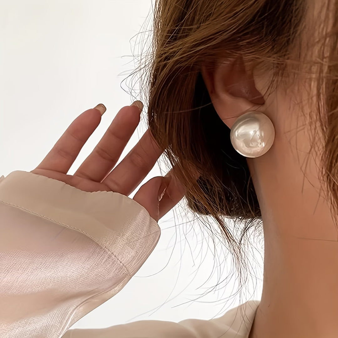 Elegant women's statement pearl stud earrings, perfect for adding timeless sophistication to any outfit.