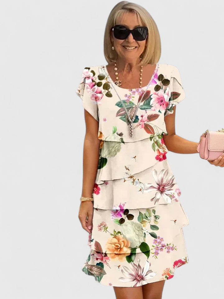 Women's elegant floral print tiered dress with short sleeves, a comfortable midi length for summer.