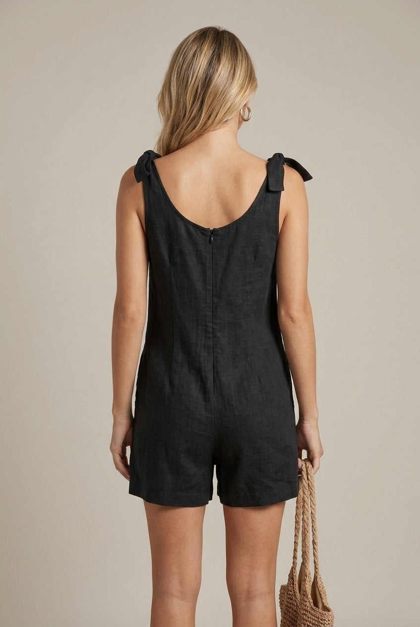 Women's square neck playsuit with charming bow straps, relaxed fit, and practical pockets for everyday style.