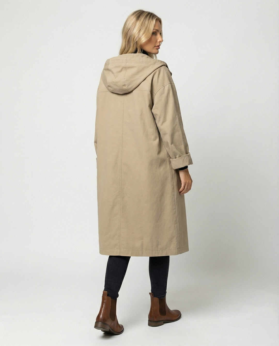 Woman confidently walking in a stylish long waterproof trench coat, ideal for elegant windproof rain protection.