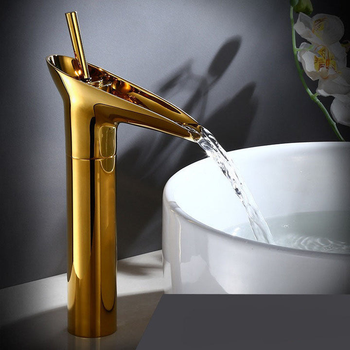Close-up of elegant brass waterfall basin tap, smooth lines, detailed finish.