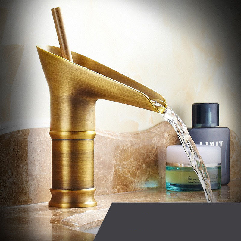 Modern brass waterfall bathroom faucet, wide spout for gentle water flow.