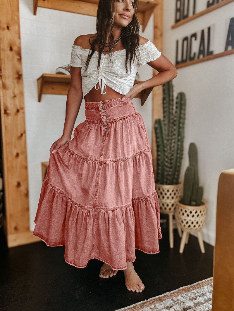 Stylish women's tiered maxi skirt showcasing a full button front, unique raw hem, and a flowing, elegant design.