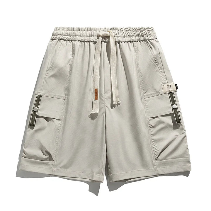 Beige men's spring cargo shorts with drawstring waist, utility pockets, perfect for casual summer comfort.