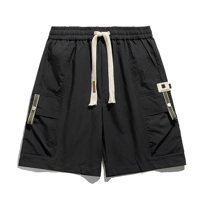 Black men's cargo shorts, relaxed fit with drawstring waist & multiple utility pockets for casual spring fashion.