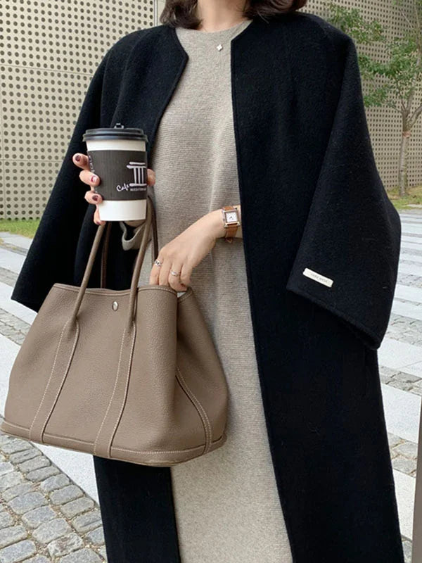Warm women's long navy coat, an essential elegant outerwear for a cozy and chic winter look.