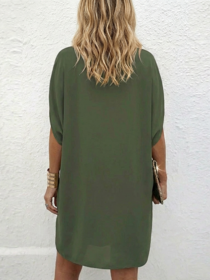 Elegant women's V-neck shift dress, draped fabric and cap sleeves offer a relaxed, stylish fit for travel.