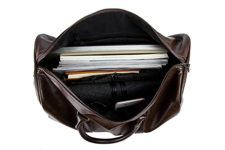Black travel duffel bag. Close-up metal hardware & adjustable shoulder strap.