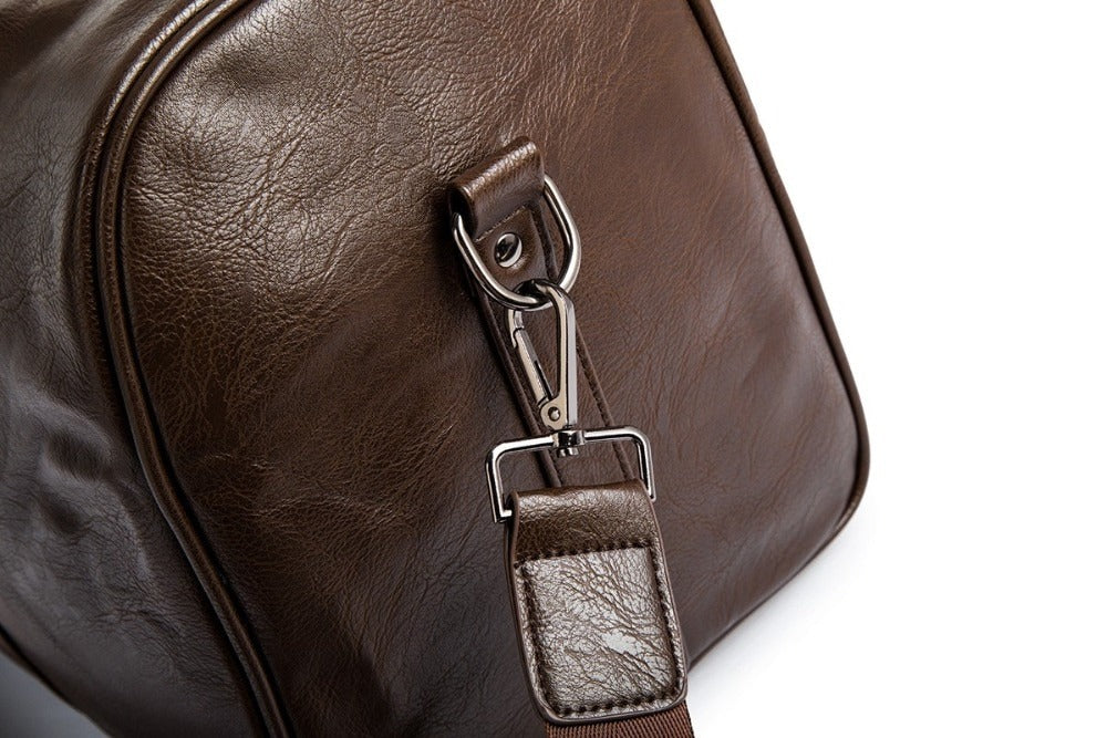 Unisex black leather-look duffel in travel setting. Fits easily into an overhead bin.