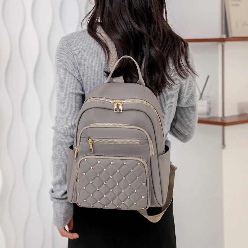 Women's lightweight water-resistant nylon backpack. Ideal for students & travelers seeking daily versatility.