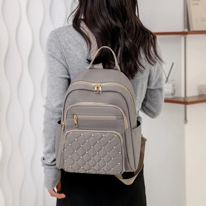 Women's lightweight water-resistant nylon backpack. Ideal for students & travelers seeking daily versatility.