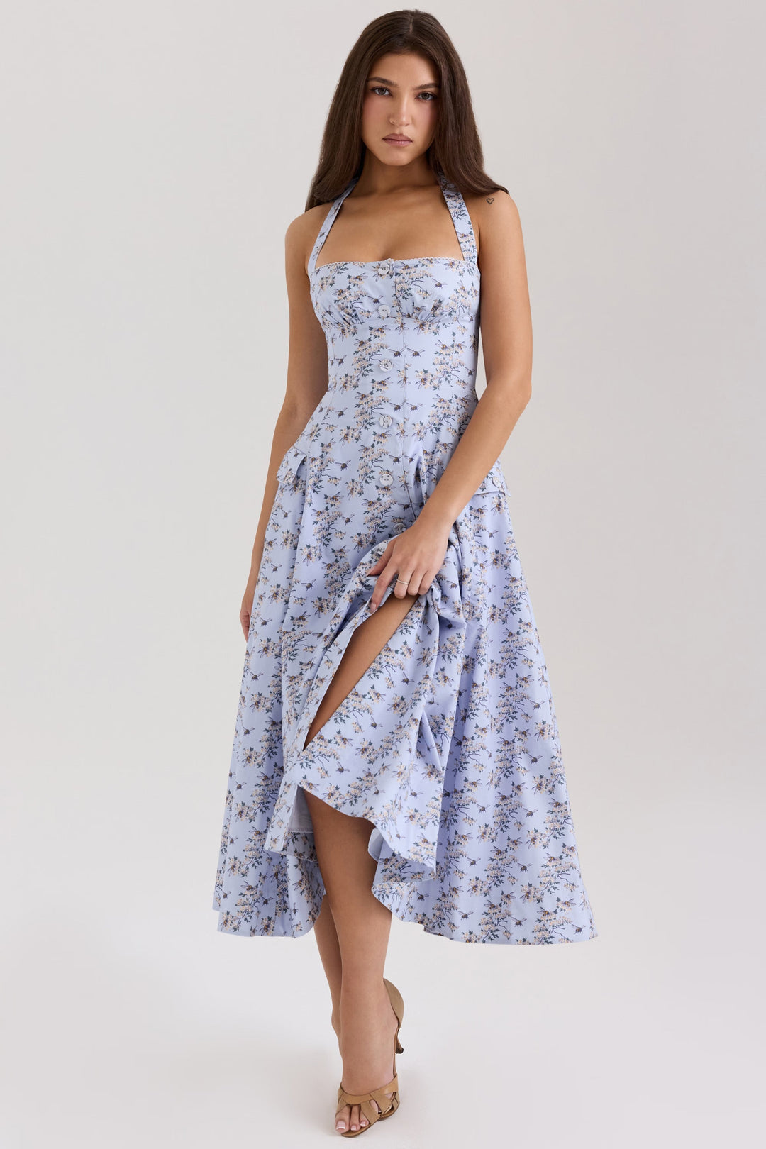 Close-up of functional pockets & button detail on a charming daisy print halter neck midi dress.