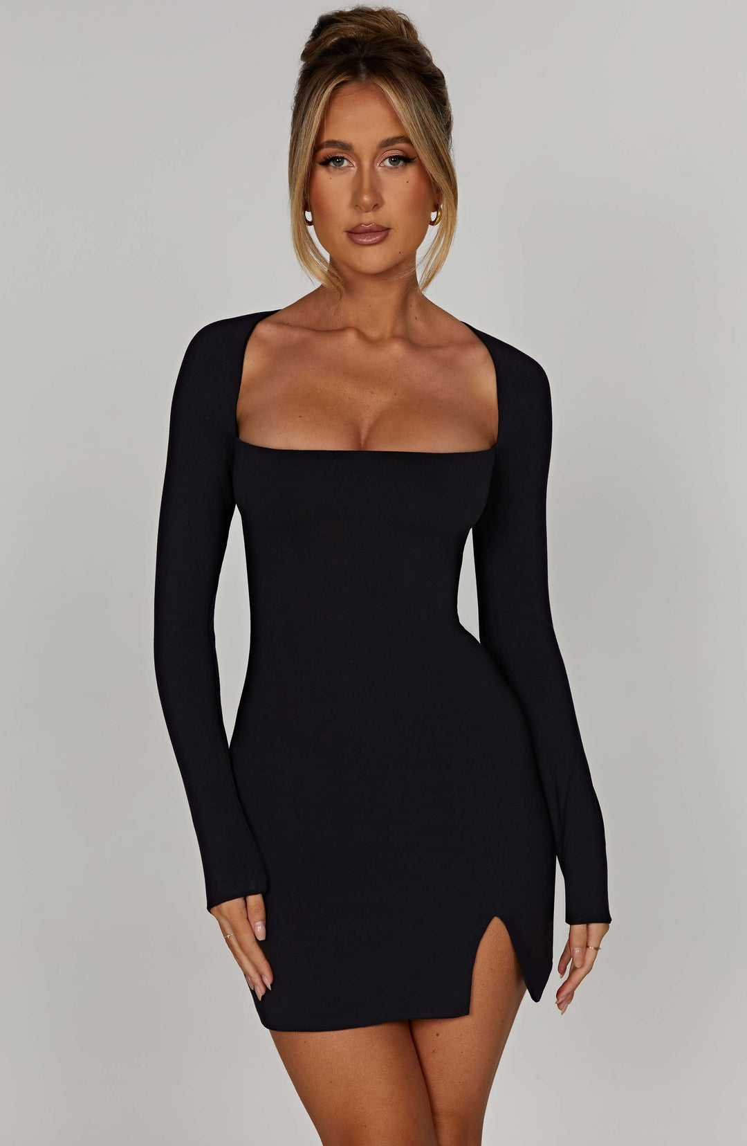 Women's black mini dress with elegant square neckline, long sleeves. Perfect for chic parties or evening wear.