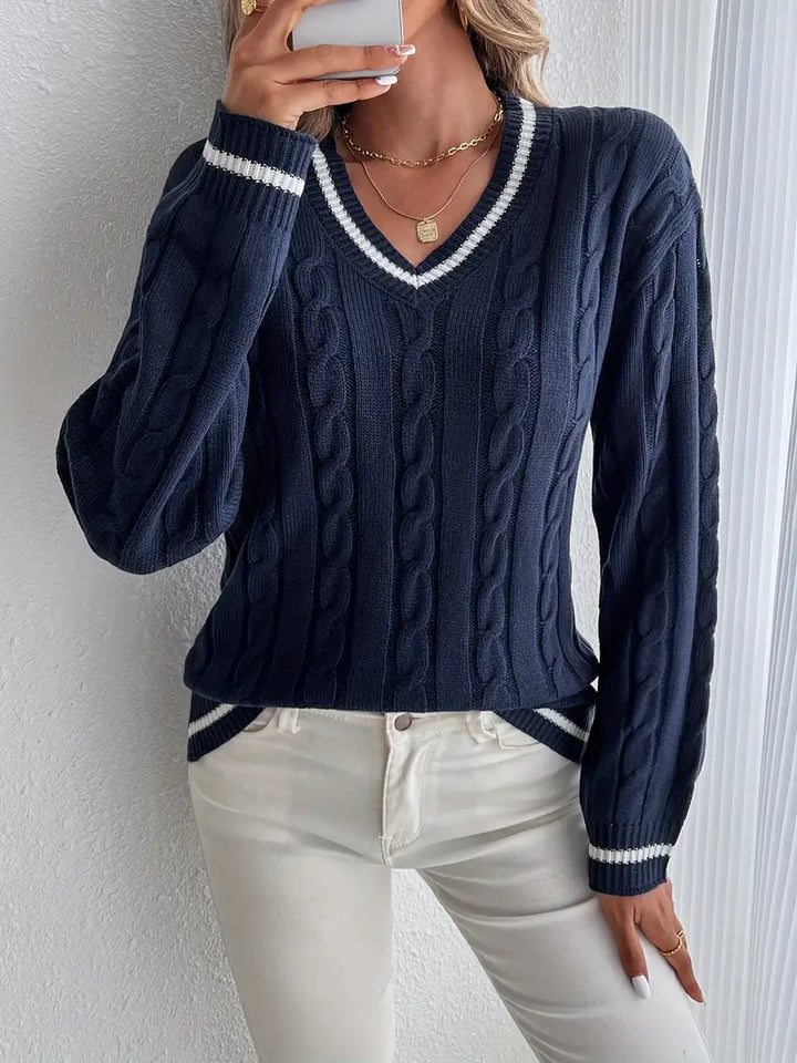 Chic women's navy V-neck cable knit sweater with long sleeves & striped trim. Perfect for winter fashion.