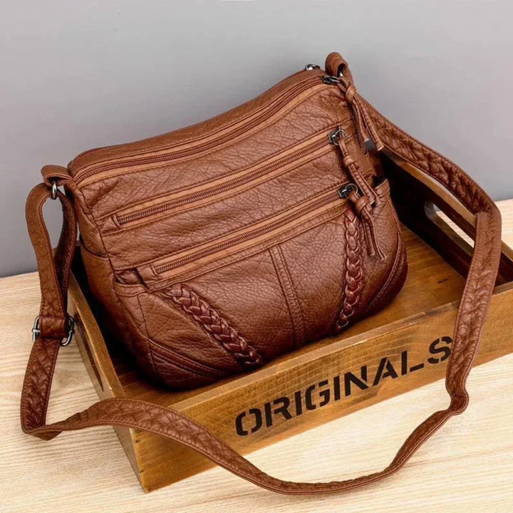 Women's organized black leather crossbody bag, spacious and secure for daily use or travel.