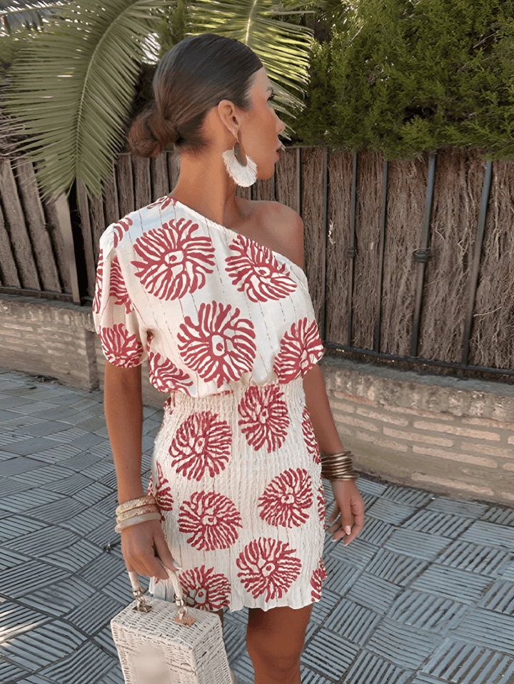 Elegant women's summer mini dress with vibrant print, one-shoulder design, perfect for beach or vacation chic.